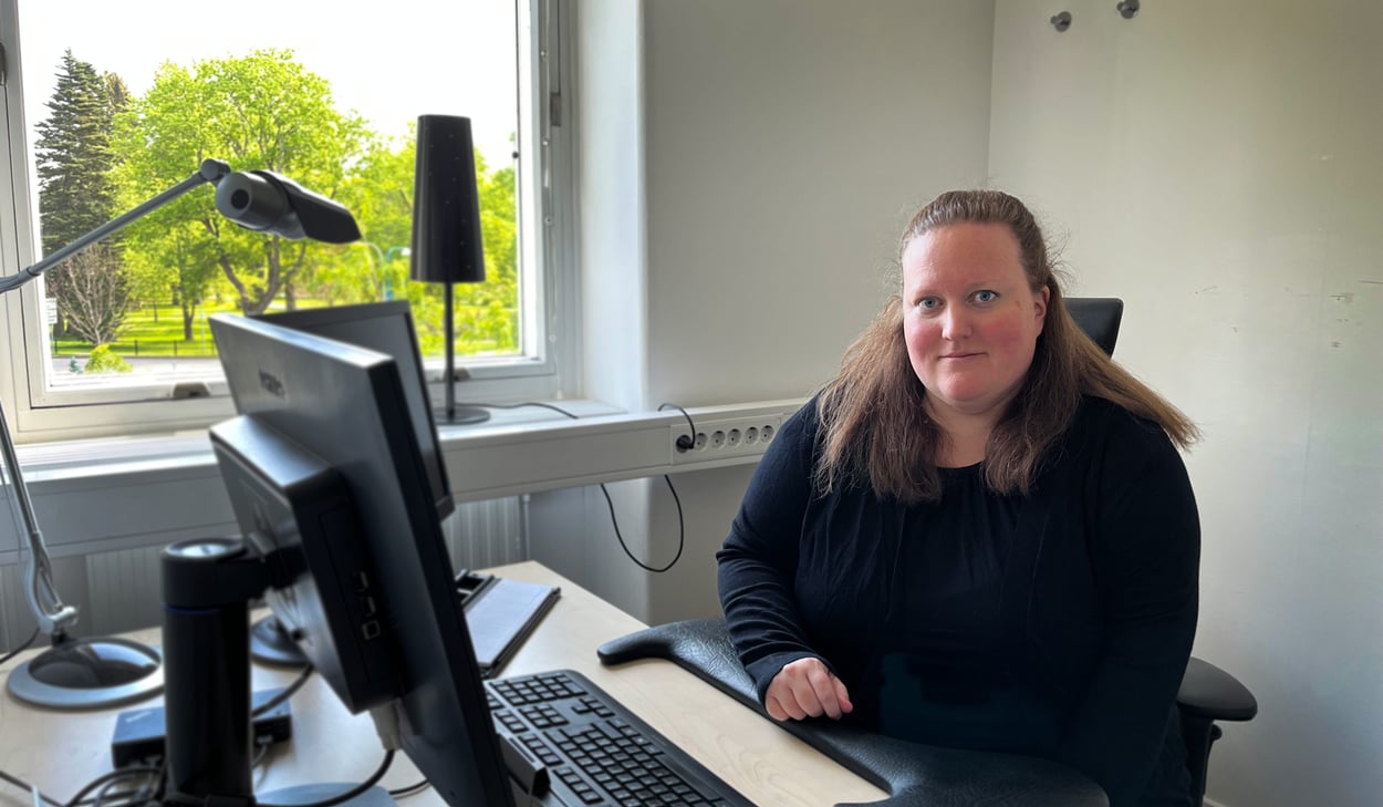 Kristin Redenvik sitter vid skrivbord och dator